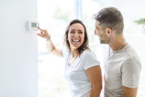 Couple Using Free Thermostat With AC Installation